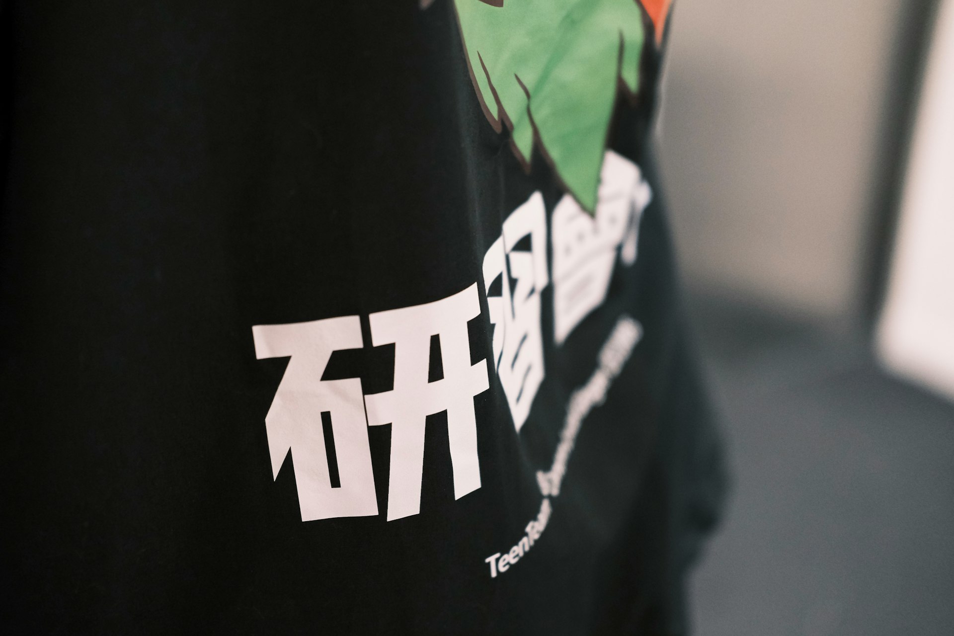 a person wearing a black t - shirt with a dragon on it